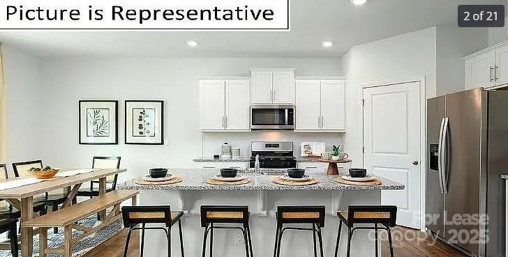 1365 Secrest Cmns Drive Monroe, NC 28112 - Photo 4 of 8 a kitchen with stainless steel appliances a table chairs and a refrigerator