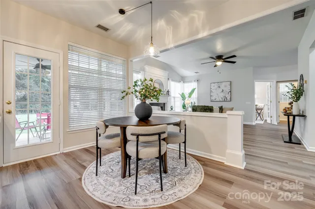 an empty room with chandelier fan and windows