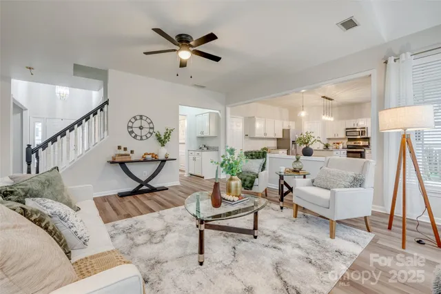 a kitchen with stainless steel appliances granite countertop a sink dishwasher a refrigerator and a stove with wooden floor