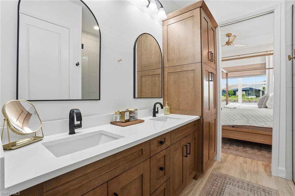 6975 Saona Court Naples, FL 34113 - Photo 13 of 30 a en suite bathroom with double sink and a mirror