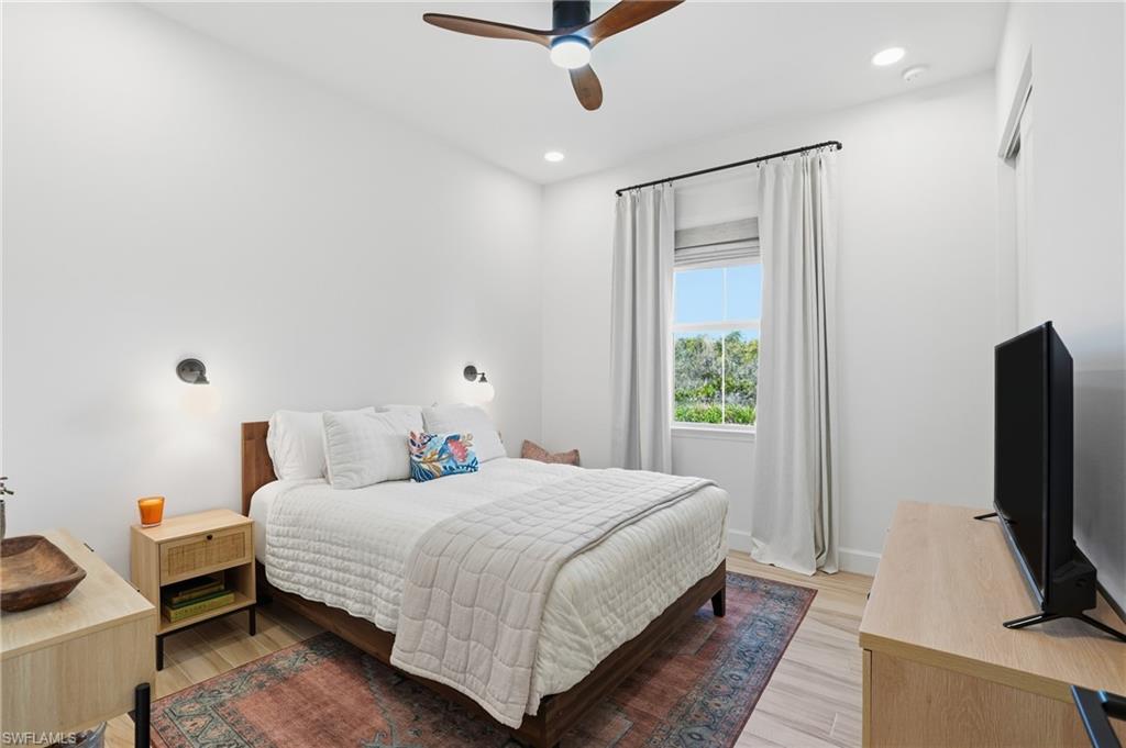 6975 Saona Court Naples, FL 34113 - Photo 17 of 30 a bedroom with a bed tv and a window