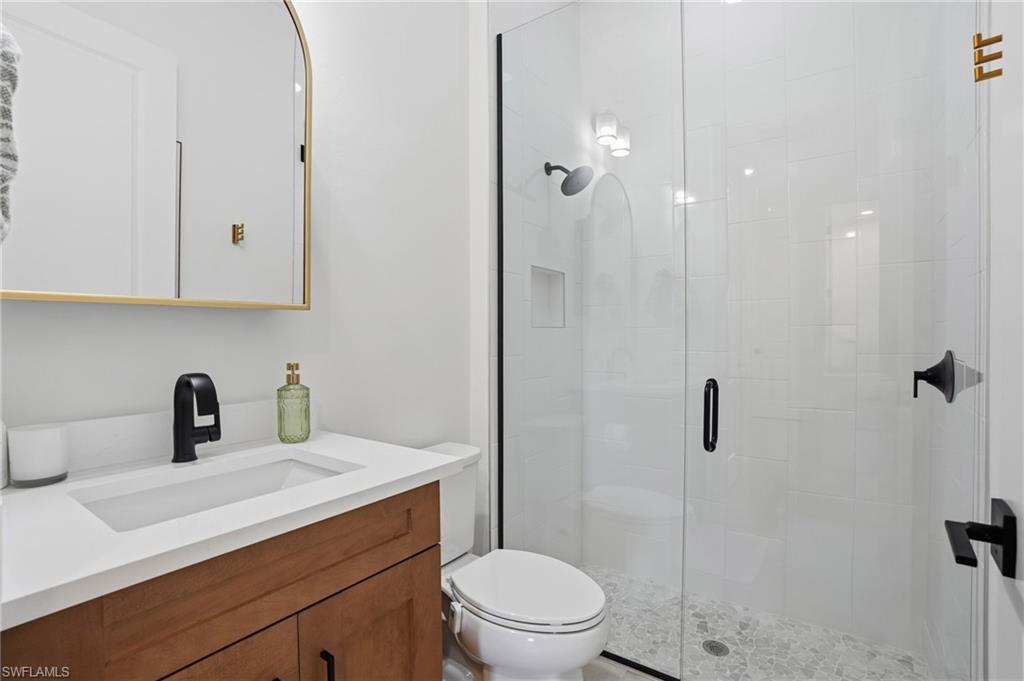 6975 Saona Court Naples, FL 34113 - Photo 18 of 30 a bathroom with a sink a toilet and shower