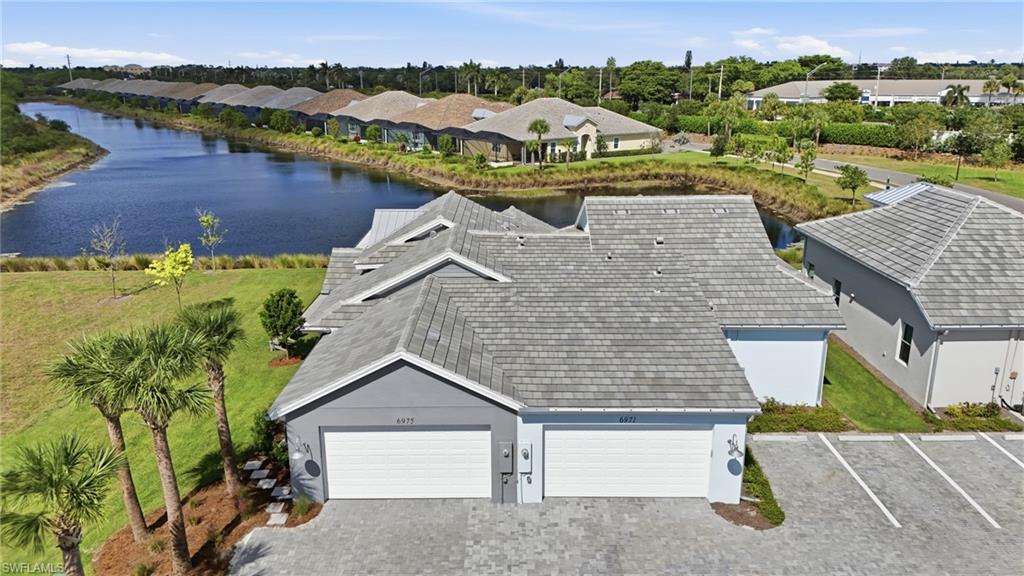 6975 Saona Court Naples, FL 34113 - Photo 29 of 30 an aerial view of a house with a yard and lake view