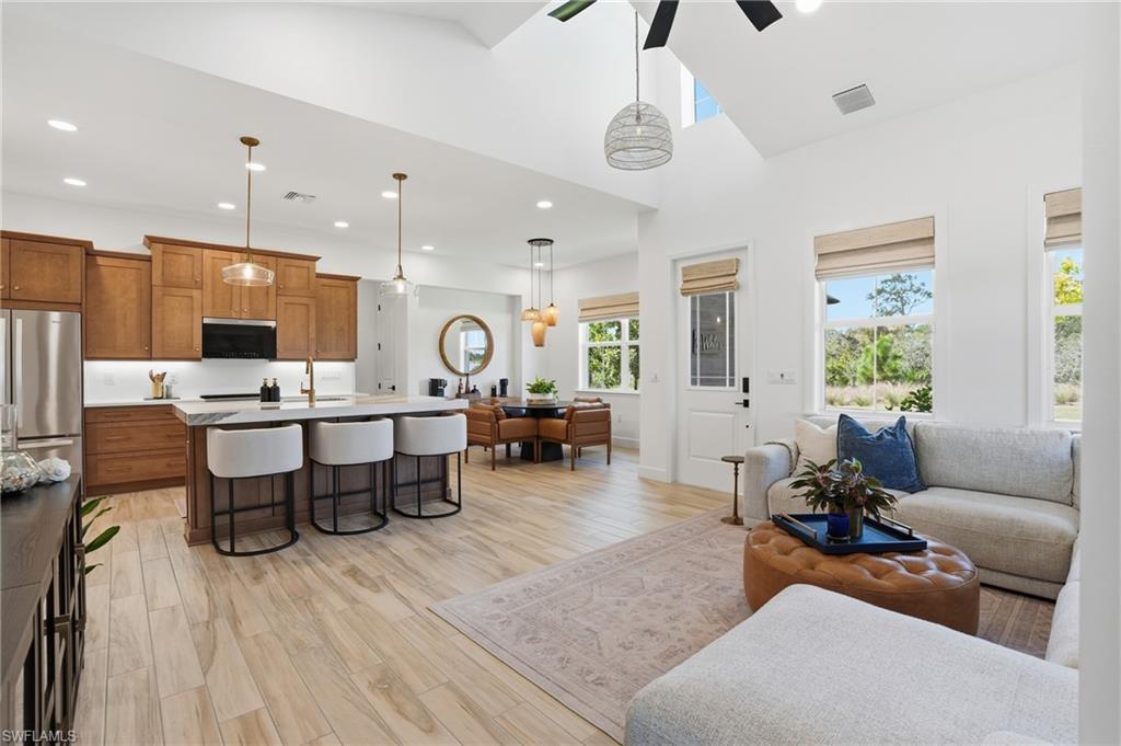 6975 Saona Court Naples, FL 34113 - Photo 7 of 30 a living room with furniture and kitchen view
