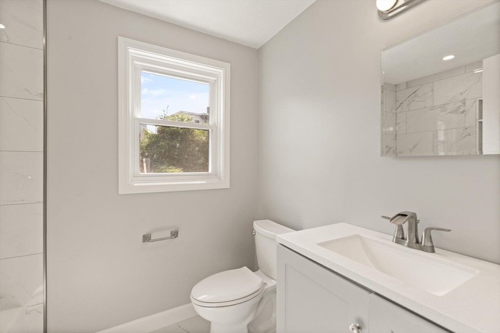 80 Newhall Street Lynn, MA 01902 - Photo 12 of 16 a bathroom with a toilet sink vanity and mirror
