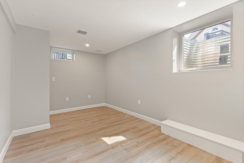 80 Newhall Street Lynn, MA 01902 - Photo 14 of 16 an empty room with wooden floor and windows