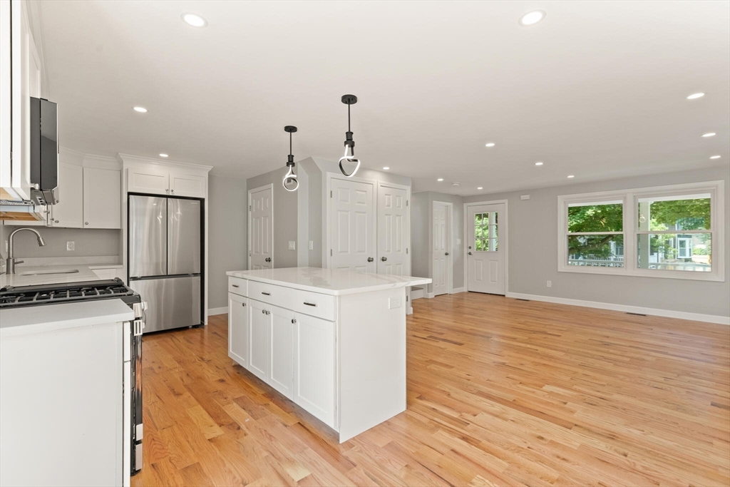 80 Newhall Street Lynn, MA 01902 - Photo 4 of 16 a large kitchen with stainless steel appliances granite countertop a stove a sink a refrigerator and white cabinets with wooden floor