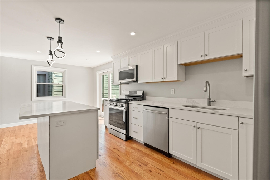 80 Newhall Street Lynn, MA 01902 - Photo 5 of 16 a kitchen with granite countertop white cabinets and stainless steel appliances