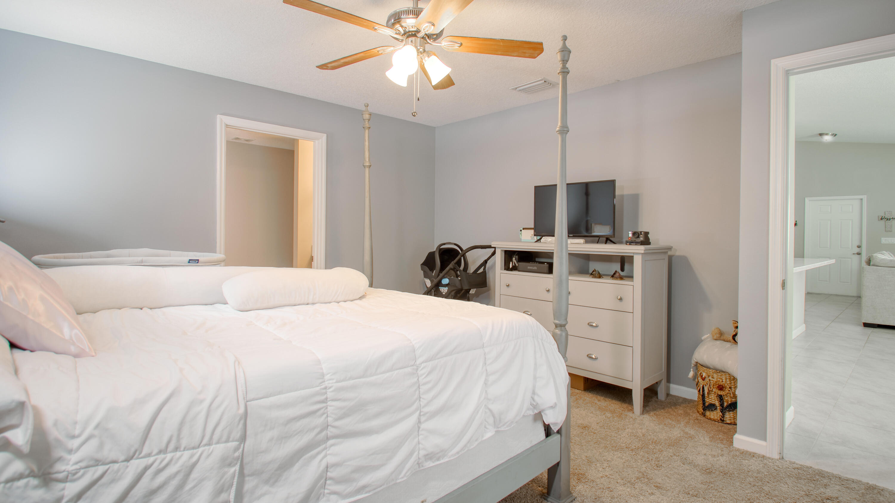 1780 Southwest Leafy Road Port St. Lucie, FL 34953 - Photo 12 of 30 a bedroom with a bed and a flat tv screen on dresser