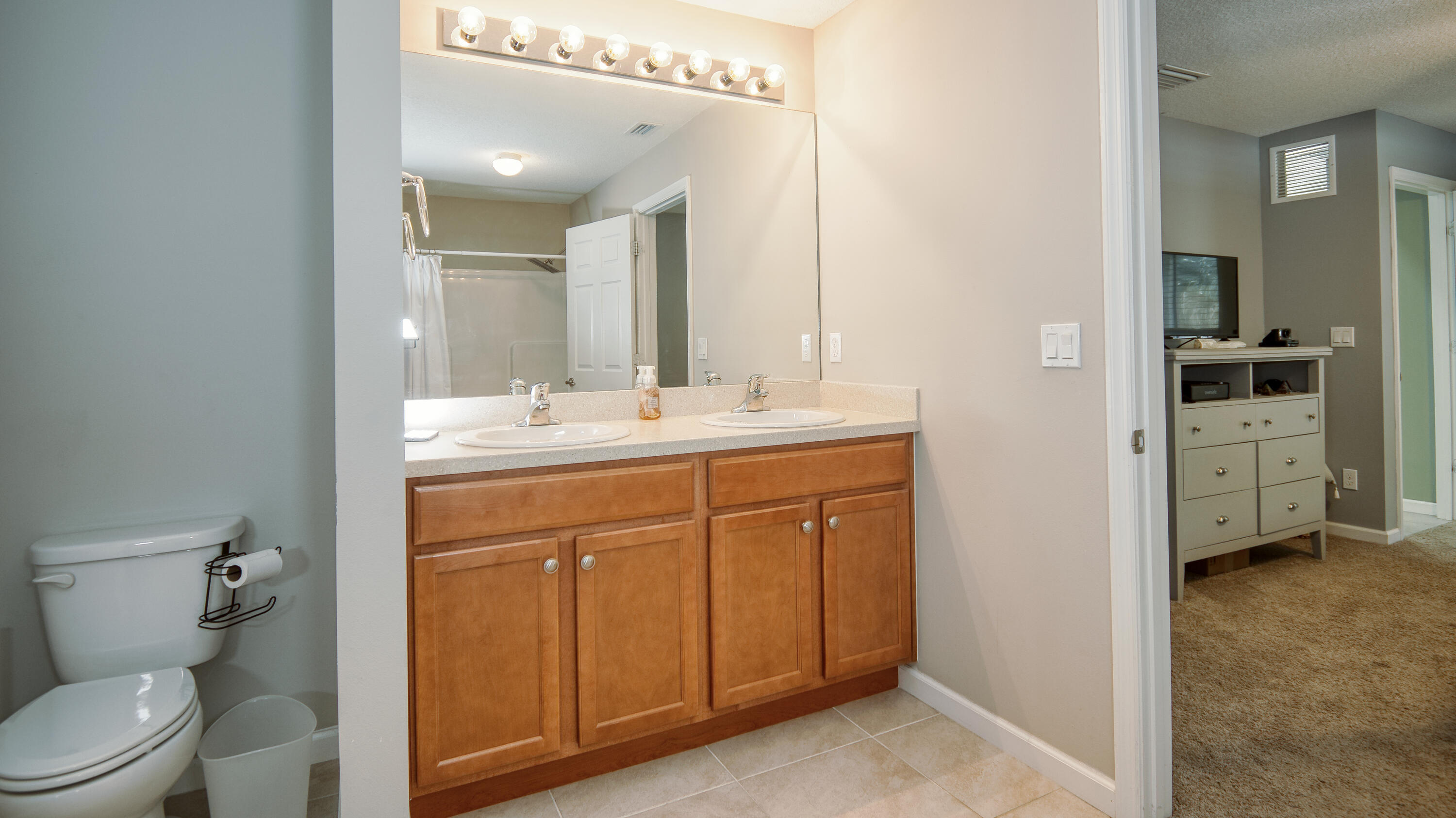 1780 Southwest Leafy Road Port St. Lucie, FL 34953 - Photo 14 of 30 a spacious bathroom with a toilet sink and a mirror