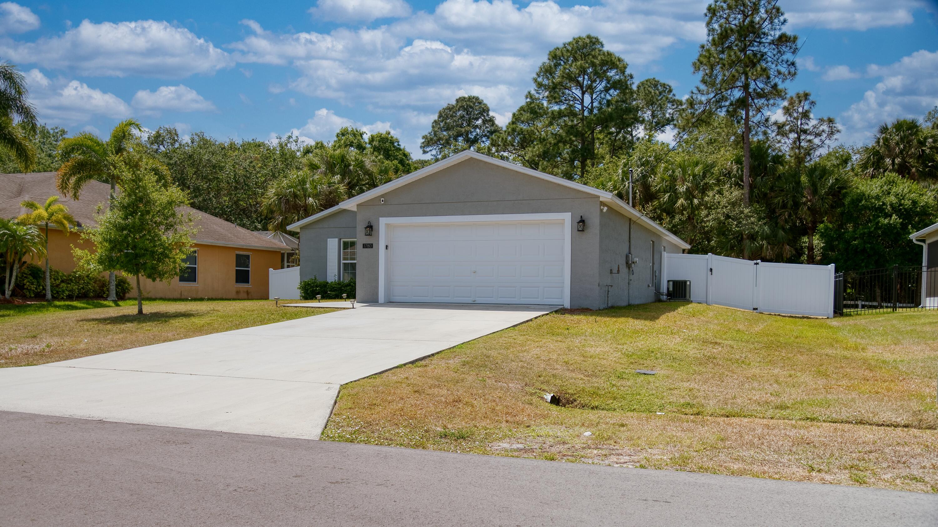 1780 Southwest Leafy Road Port St. Lucie, FL 34953 - Photo 3 of 30 a front view of a house with a yard and garage