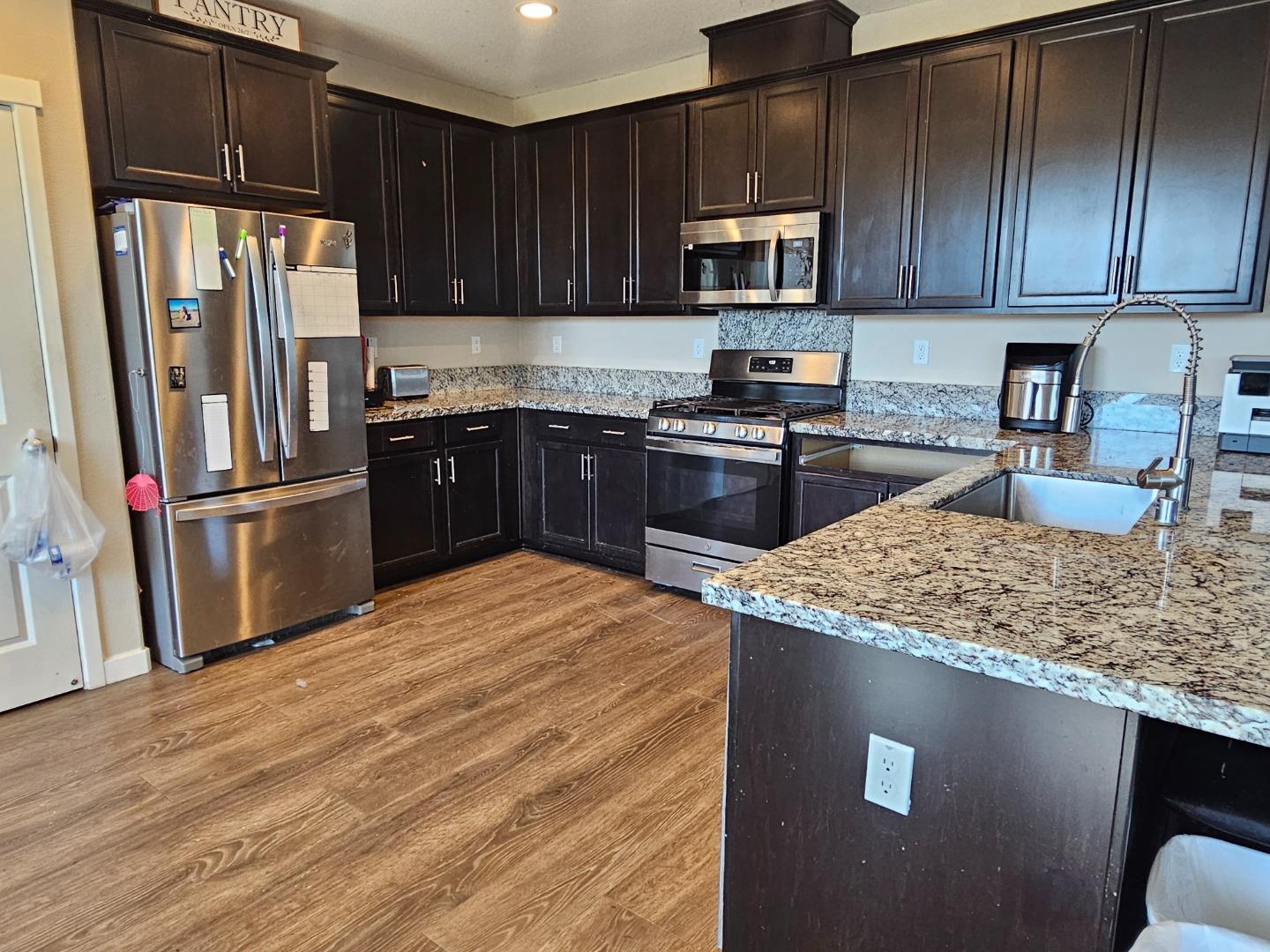 184 Raccoon Hollow Loop Copperopolis, CA 95228 - Photo 2 of 8 a kitchen with stainless steel appliances granite countertop a refrigerator stove top oven a sink and dishwasher