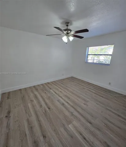 a view of empty room with wooden floor