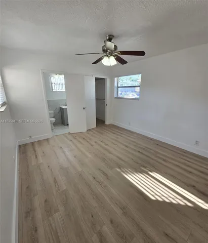 wooden floor in an empty room with a chandelier fan