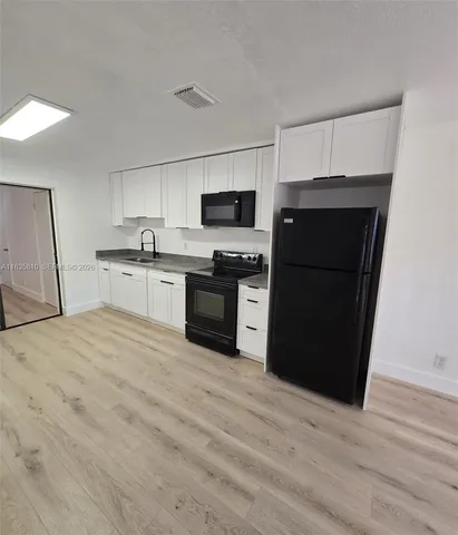 a kitchen with a refrigerator and a stove top oven