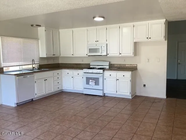 a kitchen with granite countertop a sink stove and cabinets