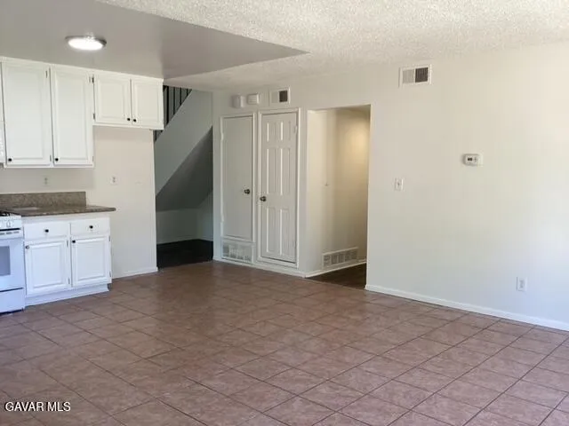 a view of kitchen with granite countertop cabinets and white appliances