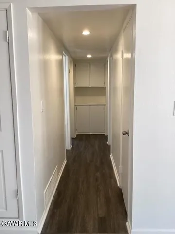 a view of a hallway with wooden floor