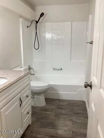 a bathroom with a granite countertop toilet a sink and a shower