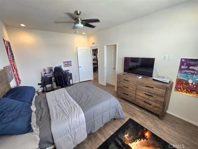 a spacious bedroom with a bed and a flat screen tv