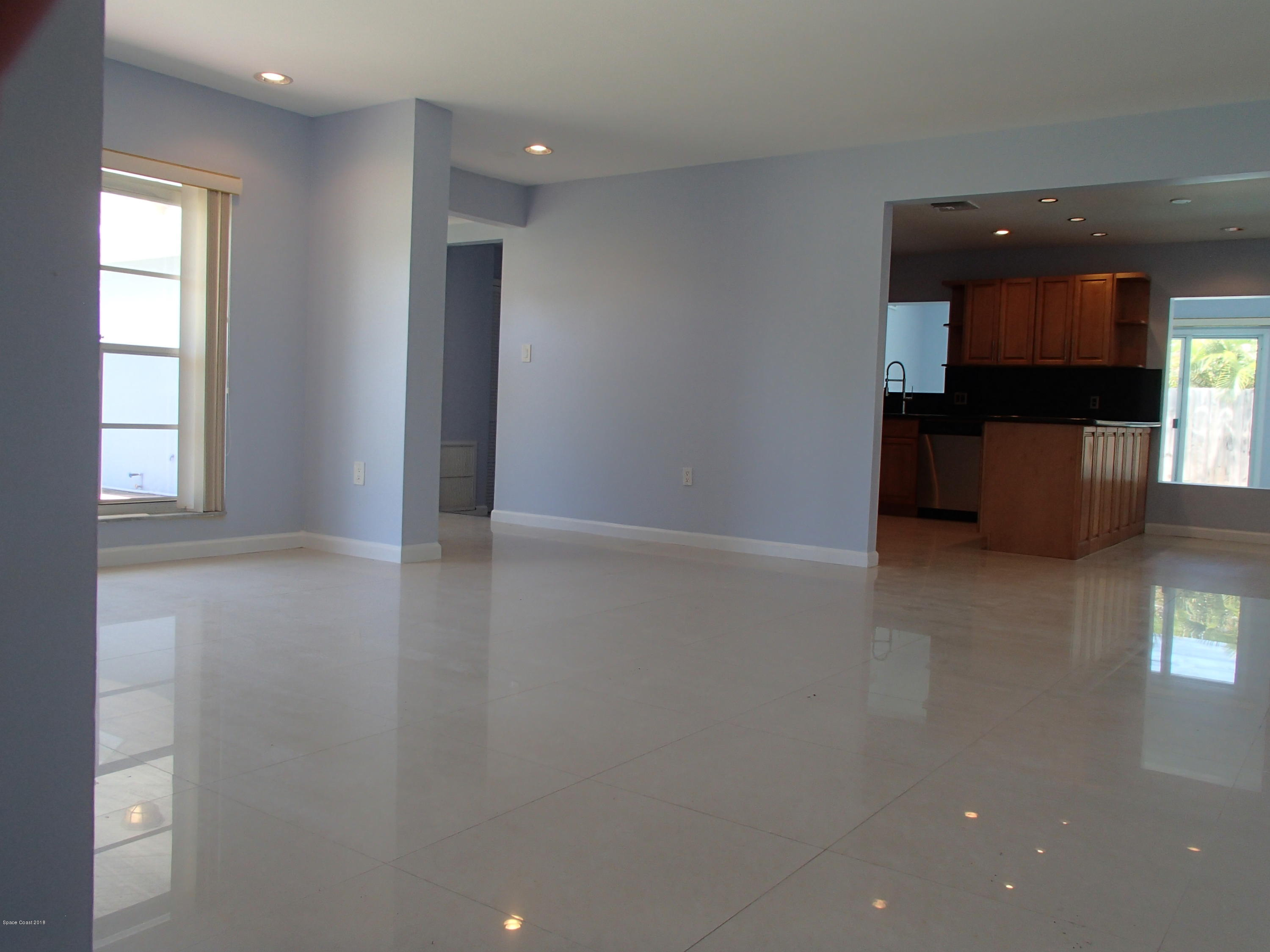 703 Bermuda Road Cocoa Beach, FL 32931 - Photo 4 of 19 an empty room with wooden floor and windows