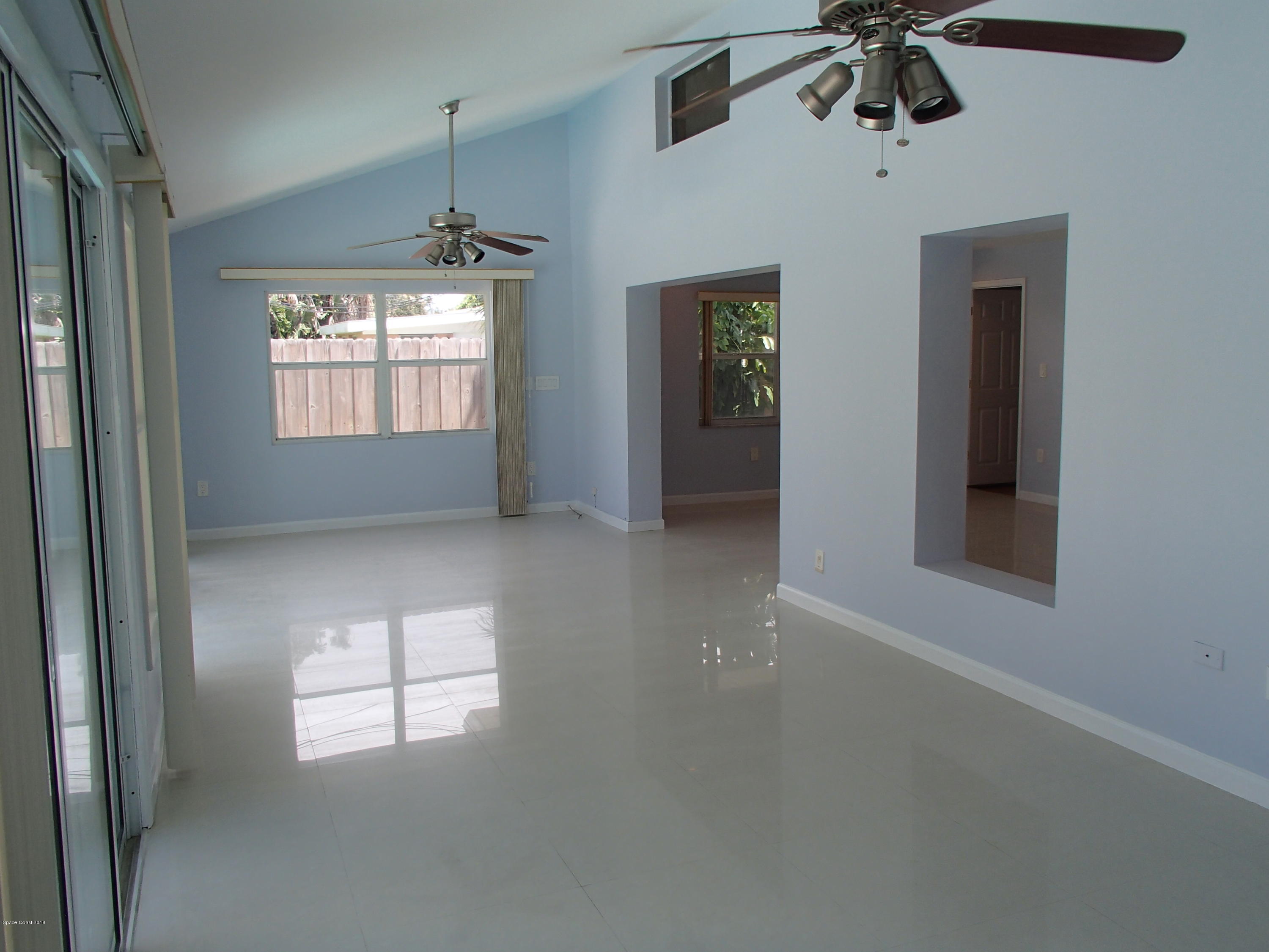 703 Bermuda Road Cocoa Beach, FL 32931 - Photo 6 of 19 en empty room with windows and ceiling fan