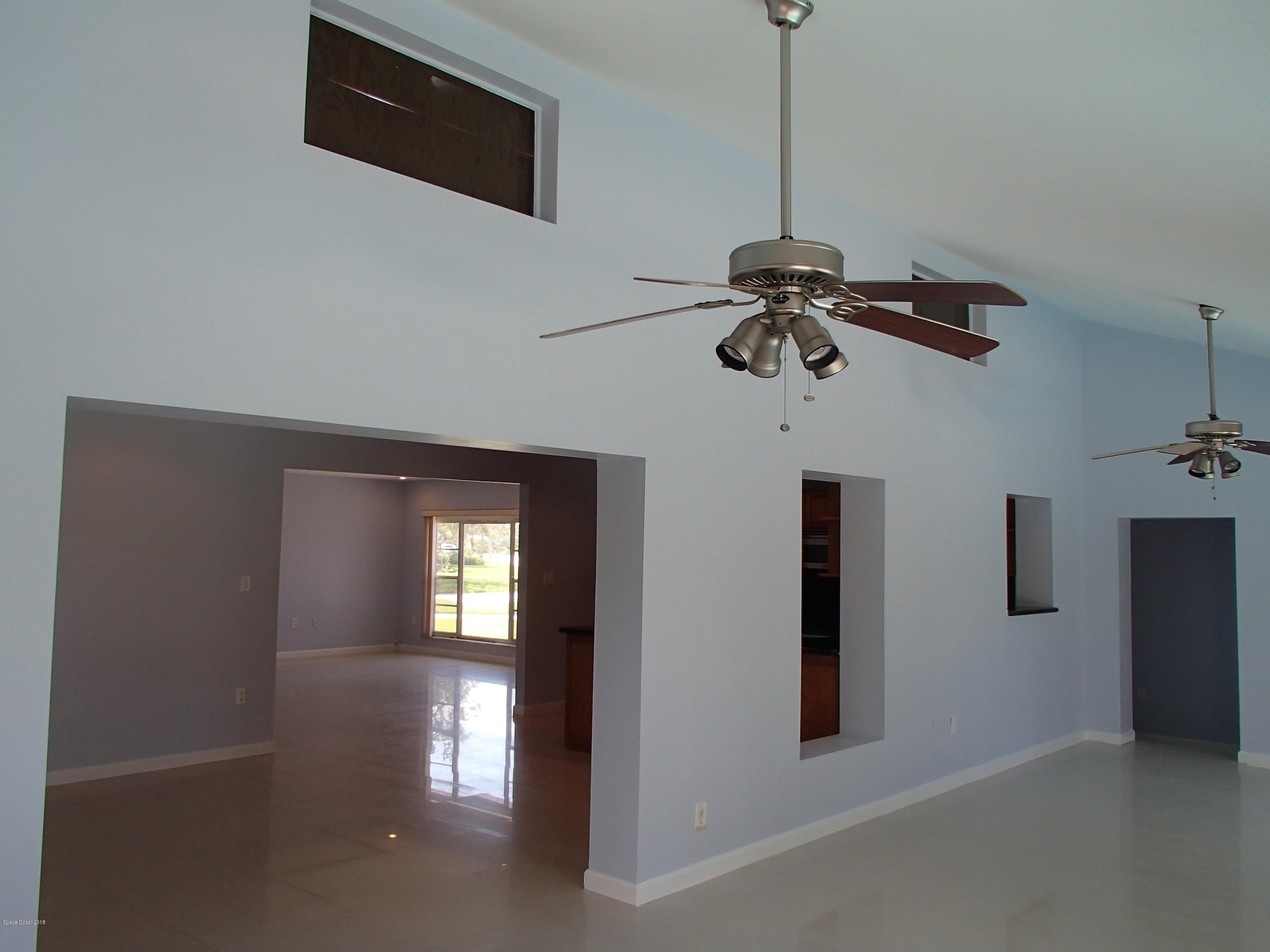 703 Bermuda Road Cocoa Beach, FL 32931 - Photo 7 of 19 a view of a hallway with a chandelier
