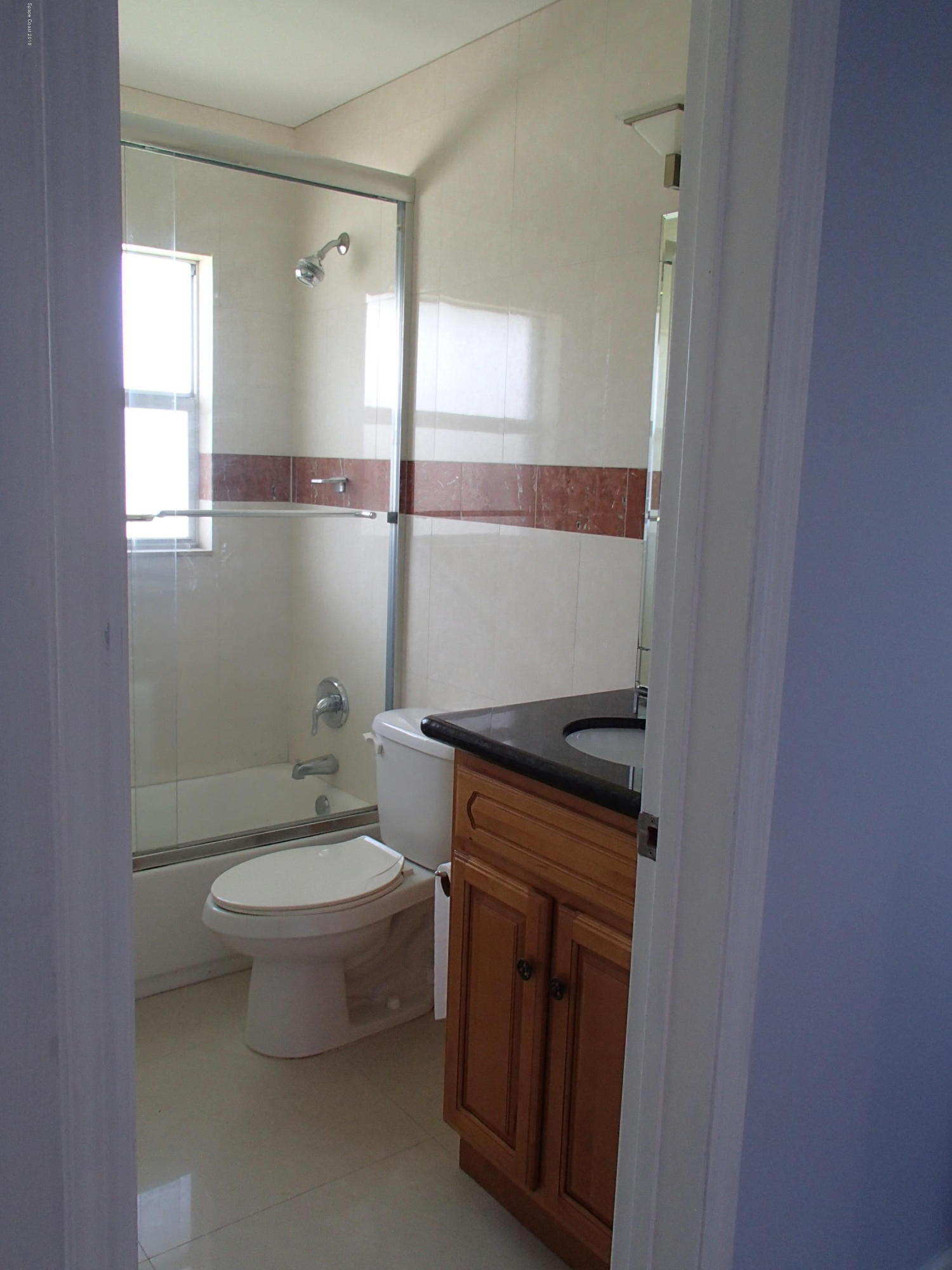 703 Bermuda Road Cocoa Beach, FL 32931 - Photo 10 of 19 a bathroom with a granite countertop toilet a sink and a mirror