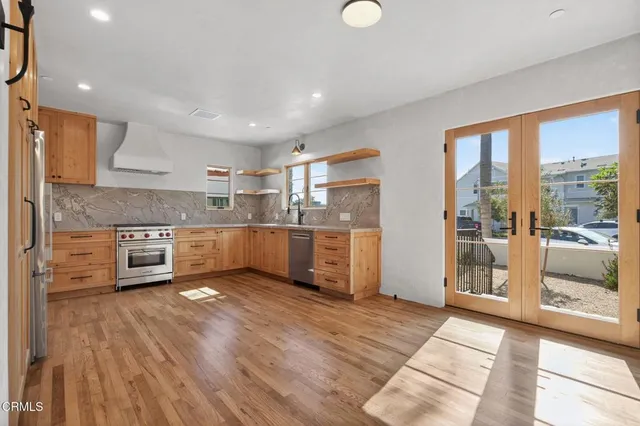 a kitchen with stainless steel appliances granite countertop a stove a sink and a refrigerator