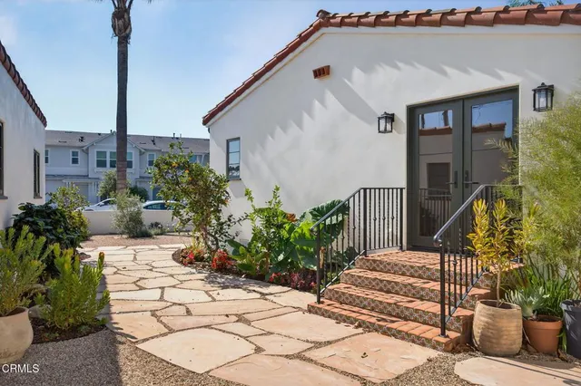 a view of a pathway of a house with potted plants