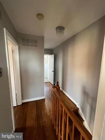 a view of a hallway with wooden floor and stairs