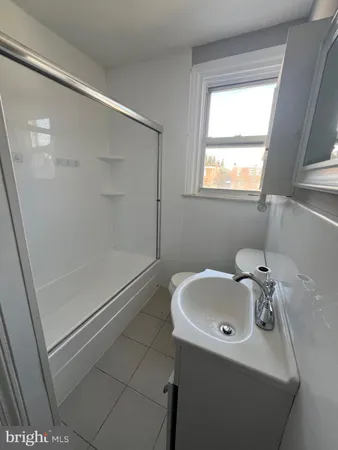a bathroom with a sink a window and shower