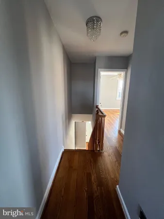 a view of a hallway with wooden floor and chair