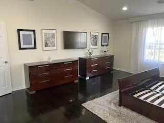 a living room with couches and dresser with wooden floor