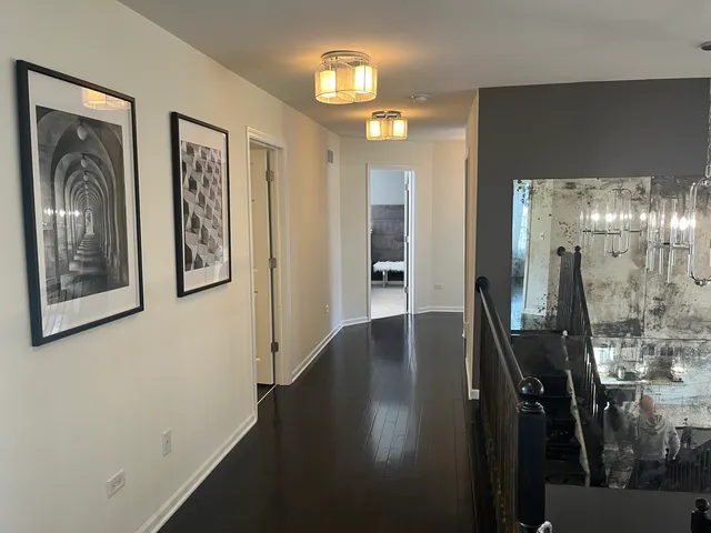a view of a hallway with mirror on furniture