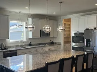 a kitchen with stainless steel appliances granite countertop a sink a stove and a refrigerator