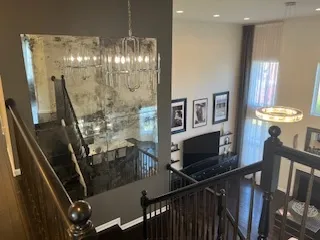 a view of a livingroom with furniture staircase wooden floor and fan