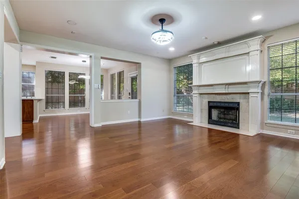 an empty room with wooden floor and fireplace