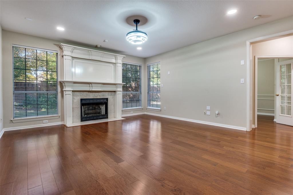 602 Signet Court Keller, TX 76248 - Photo 12 of 30 an empty room with wooden floor fireplace and windows