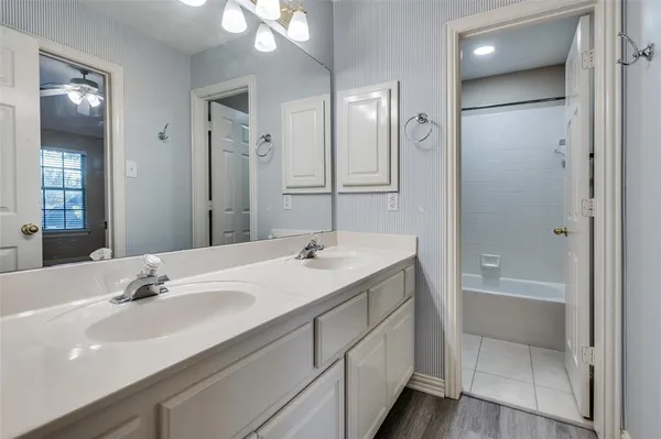 a bathroom with a double vanity sink mirror and shower