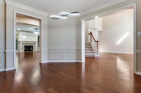 a view of a hallway with wooden floor staircase and a living room