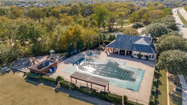 an aerial view of a house with swimming pool and trees