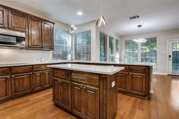 a kitchen with kitchen island granite countertop wooden cabinets a sink and a oven