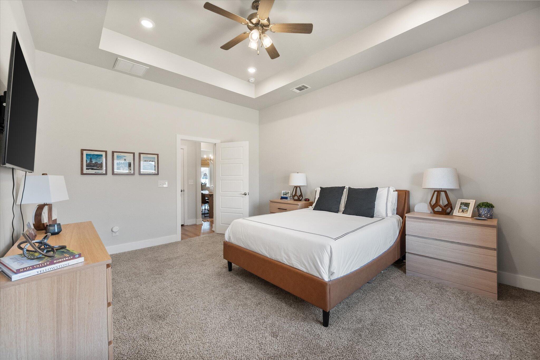 5908 Grinnell Street Lubbock, TX 79416 - Photo 14 of 27 a spacious bedroom with a bed and a chandelier