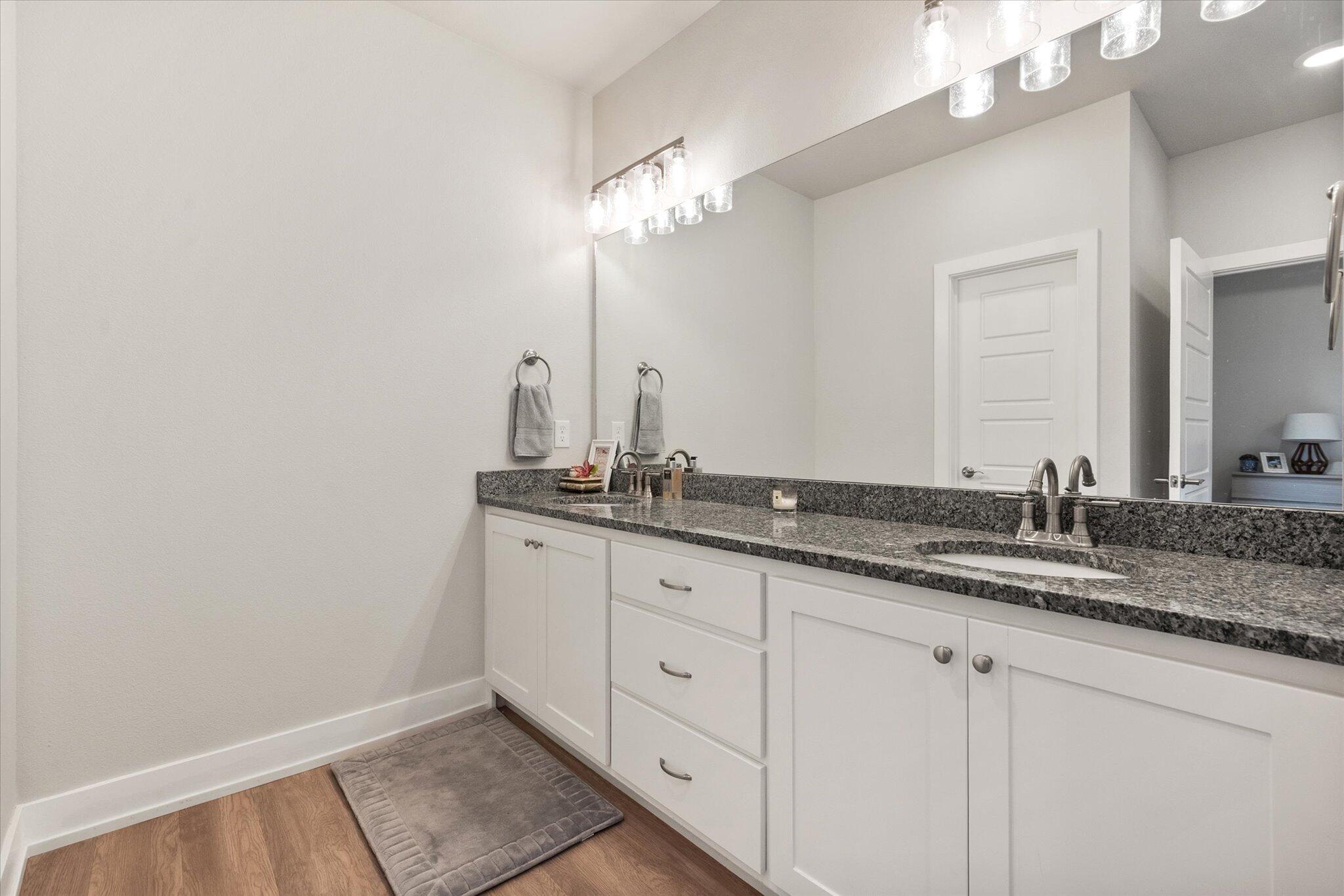 5908 Grinnell Street Lubbock, TX 79416 - Photo 15 of 27 a bathroom with a granite countertop sink and a mirror