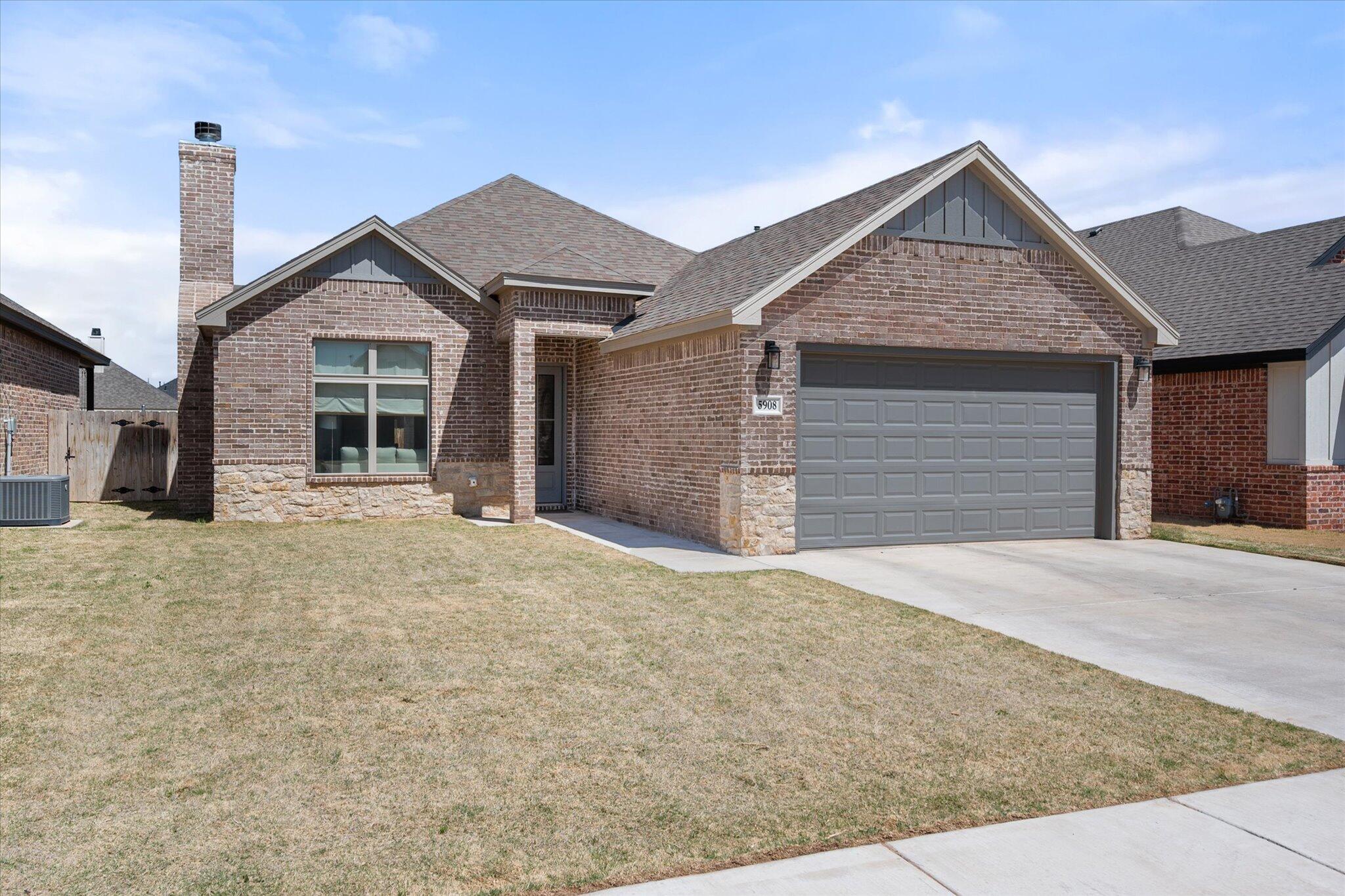5908 Grinnell Street Lubbock, TX 79416 - Photo 26 of 27 a front view of a house with a yard and garage