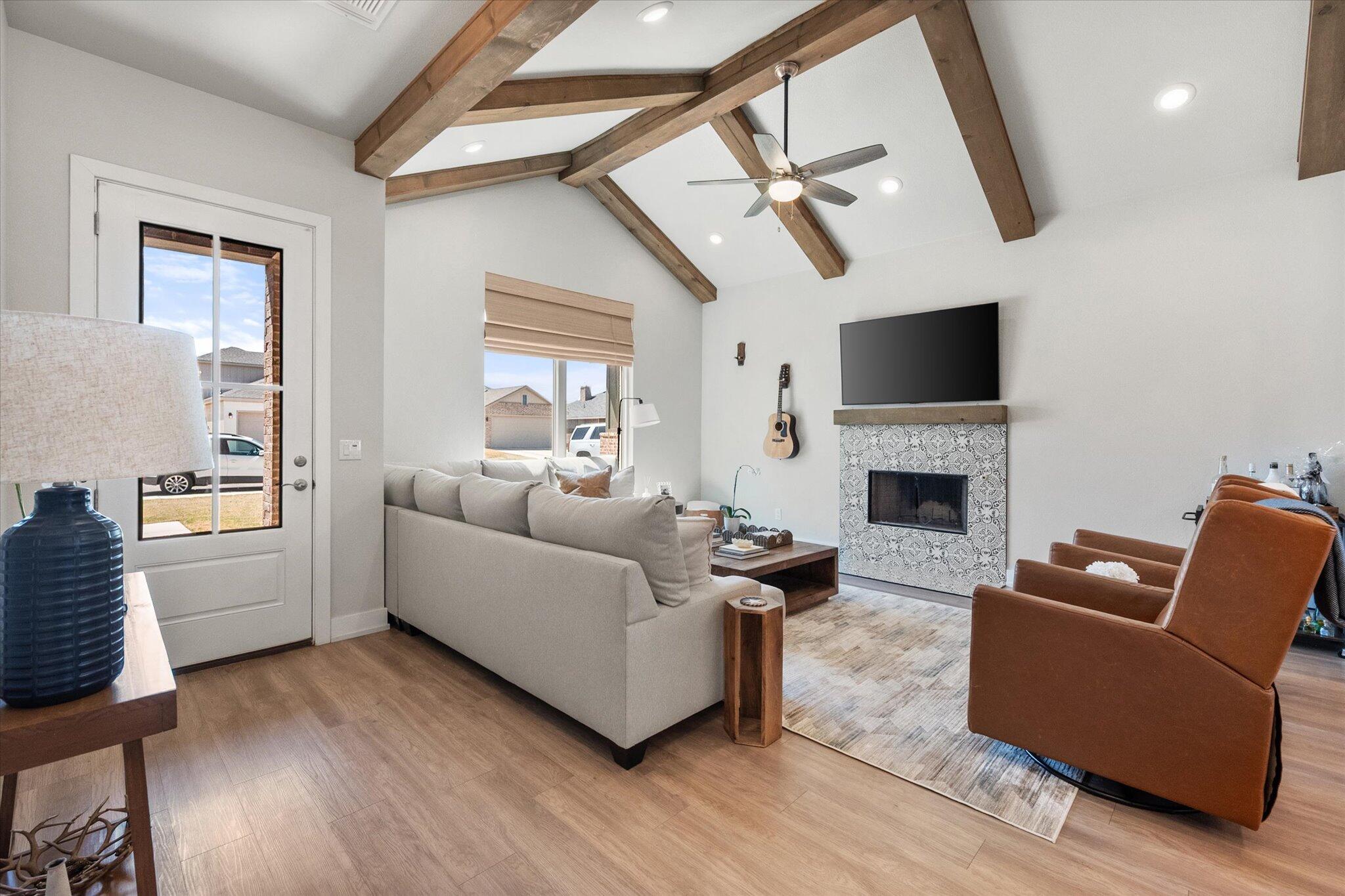 5908 Grinnell Street Lubbock, TX 79416 - Photo 5 of 27 a living room with furniture a flat screen tv and a fireplace