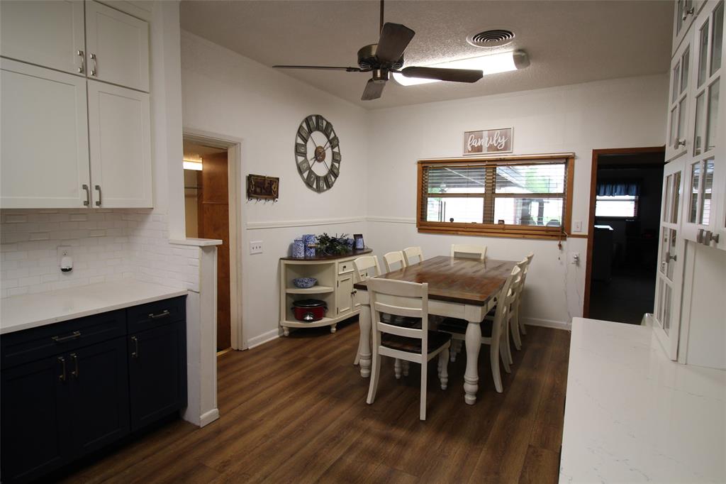 220 North 14th Avenue Munday, TX 76371 - Photo 11 of 34 a kitchen with stainless steel appliances kitchen island granite countertop a table chairs and a refrigerator