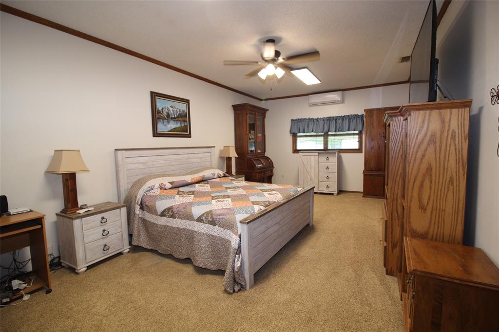 220 North 14th Avenue Munday, TX 76371 - Photo 12 of 34 a bedroom with a bed and a chandelier