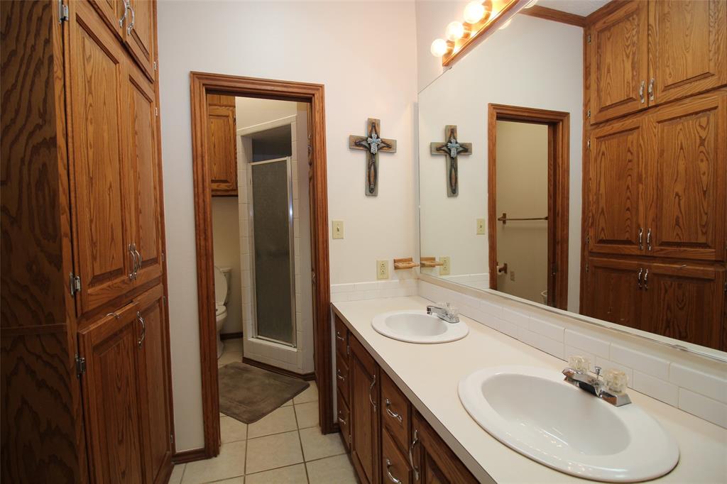 220 North 14th Avenue Munday, TX 76371 - Photo 14 of 34 a bathroom with a sink and mirror